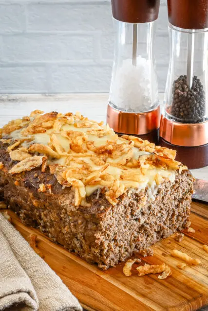 Sliced French onion meatloaf with Gruyère cheese and fried onion topping.