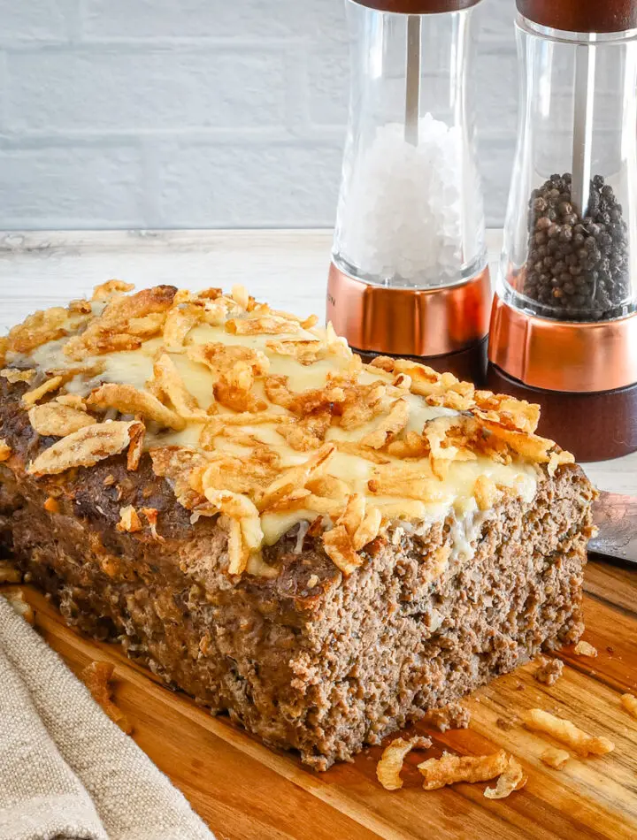 Sliced French onion meatloaf with Gruyère cheese and fried onion topping.