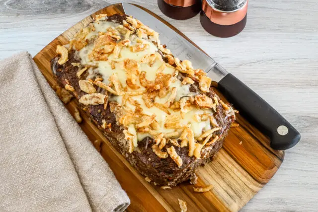 Overhead photo of the baked French onion meatloaf with Gruyère cheese and fried onion topping.