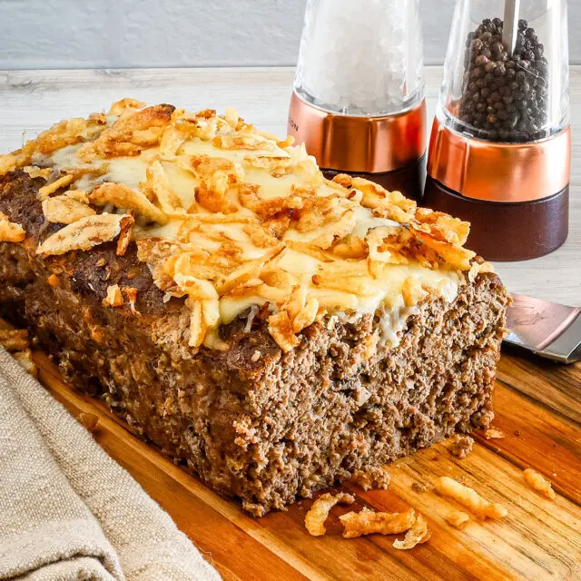 Sliced French onion meatloaf with Gruyère cheese and fried onion topping.