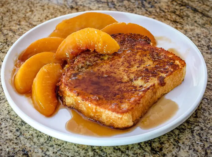 french toast on a plate with caramelized peaches