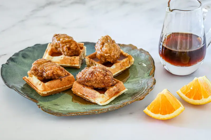chicken nuggets on waffle pieces with maple srup