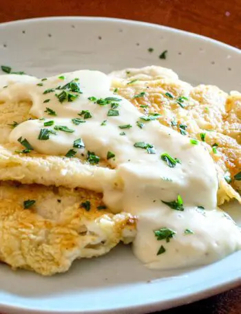 pan fried sole on a plate with parmesan sauce