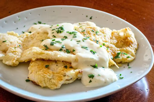 pan fried sole on a plate with parmesan sauce