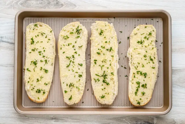 Spread garlic butter over the bread and sprinkle with chopped parsley.