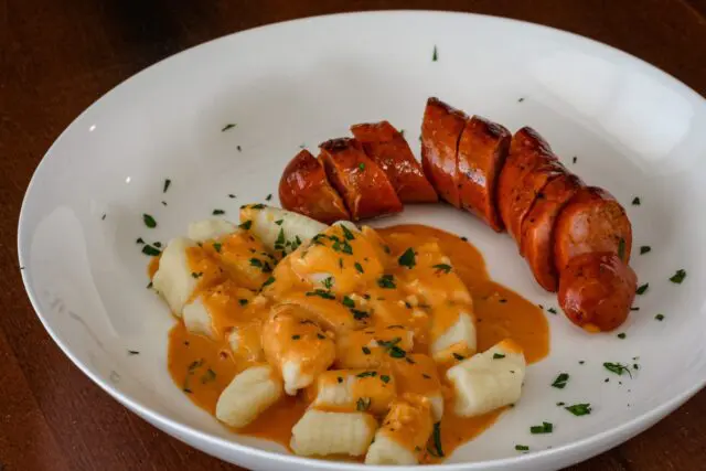 homemade gnocchi on a plate with andouille sausage and a sauce