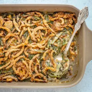 classic green bean casserole in a baking dish with serving spoon