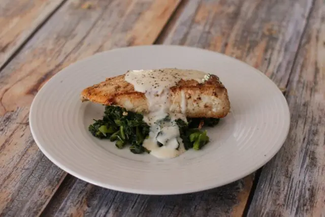 a halibut fillet on spinach