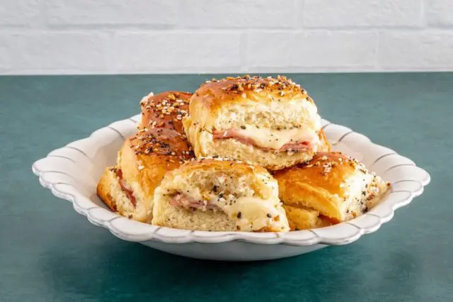 baked ham and cheese sliders with everything bagel seasoning in a bowl