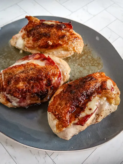 Serving tray with skin-on chicken breasts with capicola and provolone.