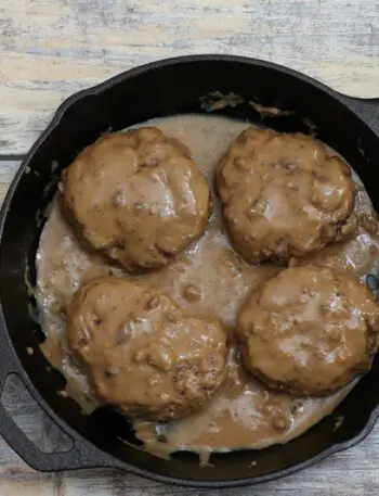 Overhead photo of hamburger steaks with gravy.