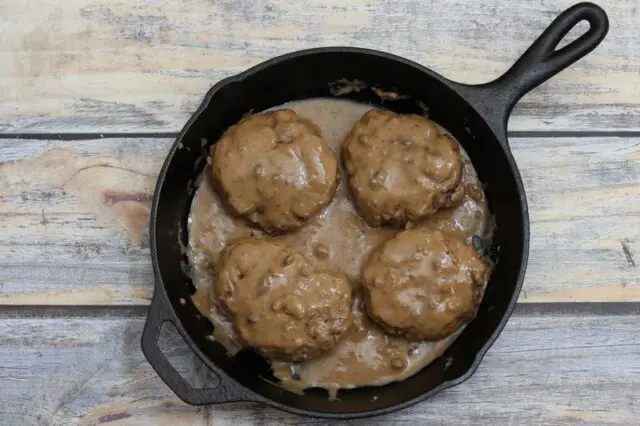 Overhead photo of hamburger steaks with gravy.