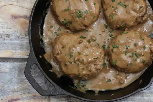 Overhead photo of hamburger steaks with gravy.