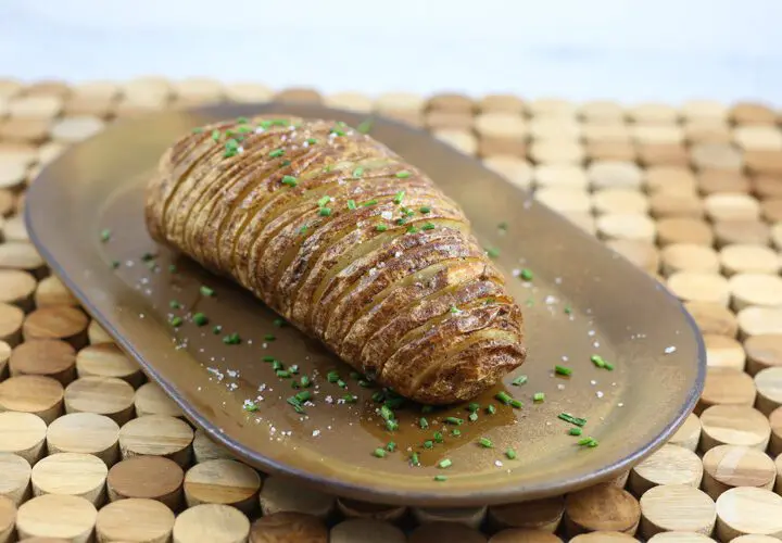 A baked hasselback potato on a plate