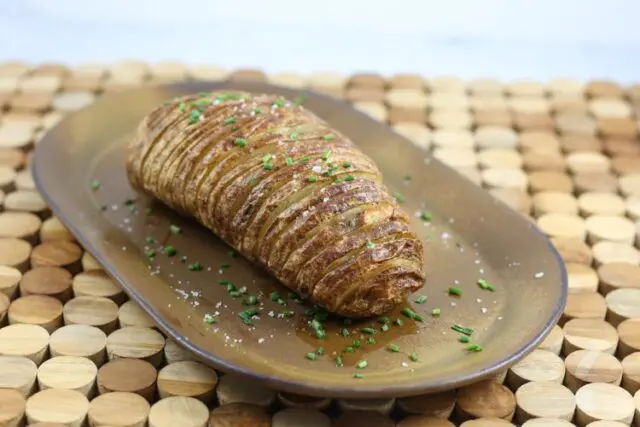 A baked hasselback potato on a plate