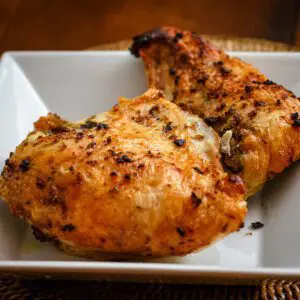 a serving dish with roasted chicken breasts with garlic and herbs