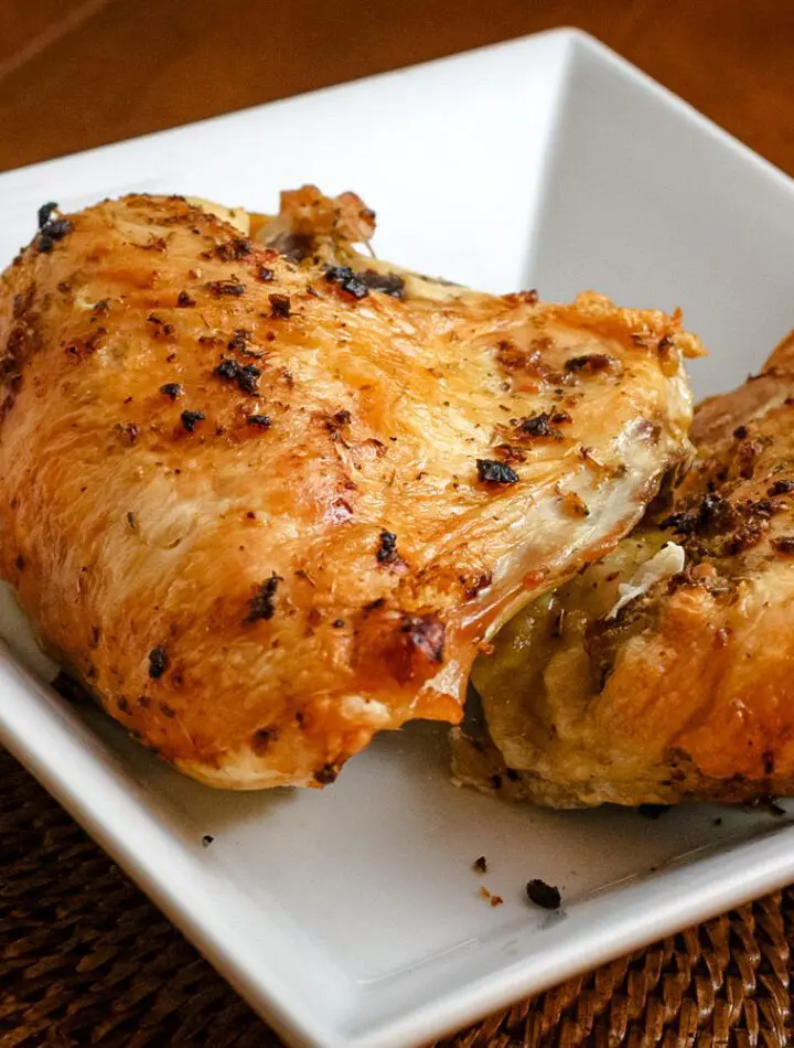 roasted herb and garlic split chicken breasts in a serving dish