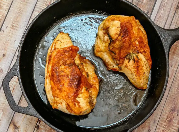 herb roasted split chicken breasts in a cast iron pan