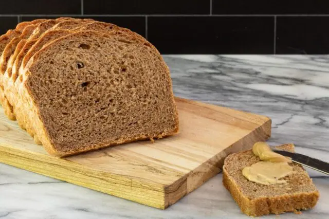 Sliced homemade pumpernickel bread on a cutting board