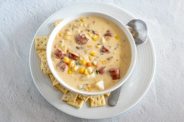 hot dog chowder in a bowl with mini saltine crackers on the side