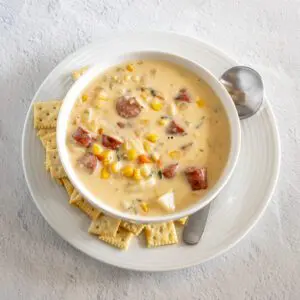 hot dog chowder in a bowl with crackers