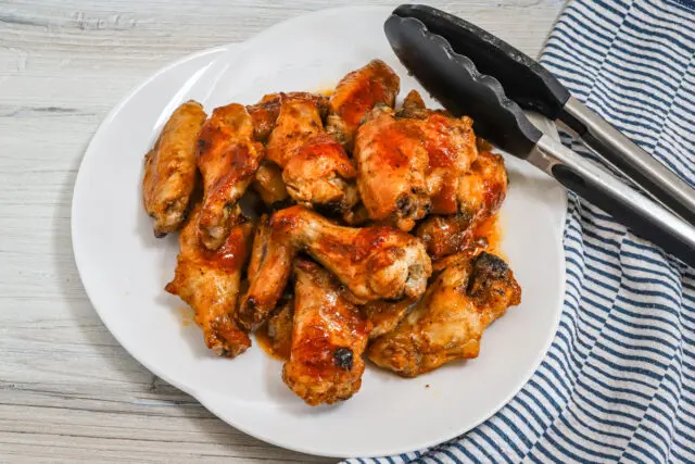 Hot honey wings made with a coating of butter, hot sauce, lime zest, garlic powder, and onion powder.