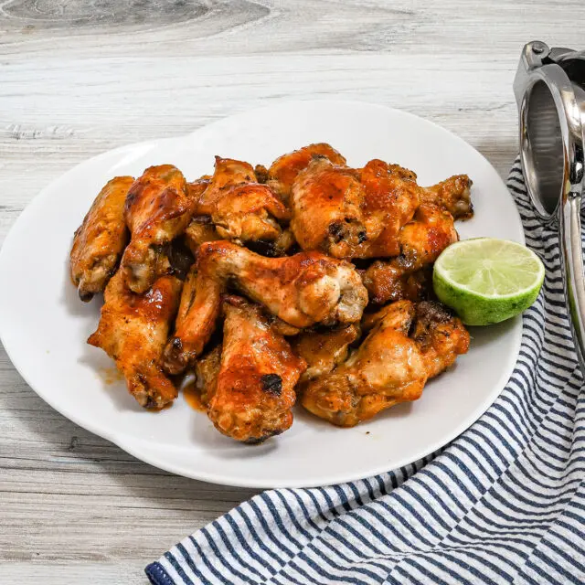 Hot honey chicken wings preparation with hot sauce, butter, honey, lime zest and juice, garlic powder, and onion powder.