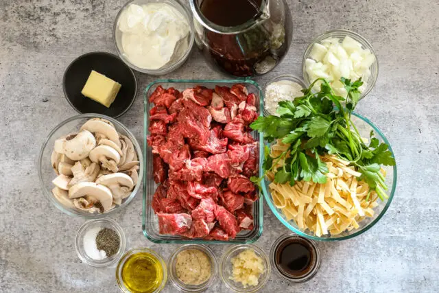 Instant Pot beef stroganoff ingredients, including top sirloin beef, noodles, mushrooms, and beef broth.