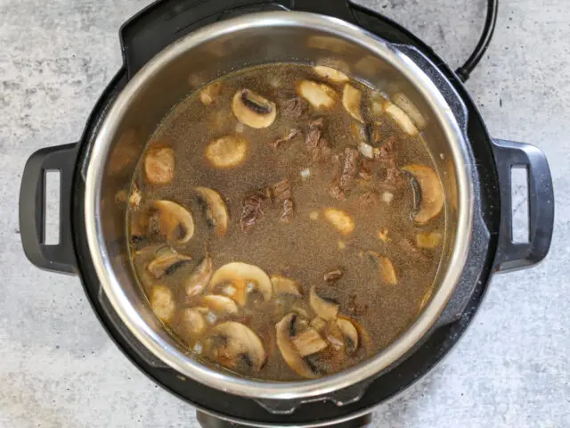 Beef broth is added to the Instant Pot.