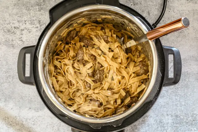 The Instant Pot with perfectly cooked beef stroganoff with noodles.