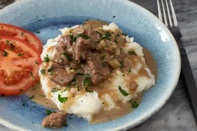 closeup of sirloin tips on potatoes with gravy