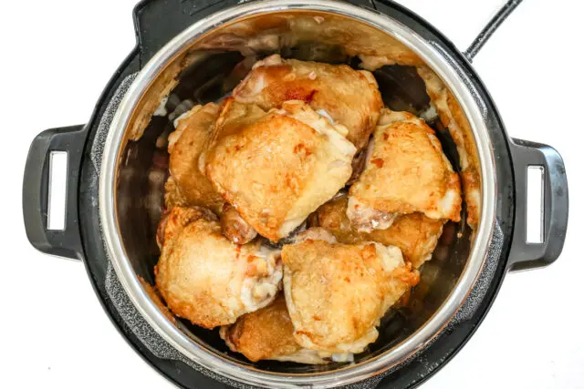 Browned chicken thighs in the Instant Pot pressure cooker.