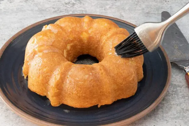 brushing the doughnut cake with melted butter