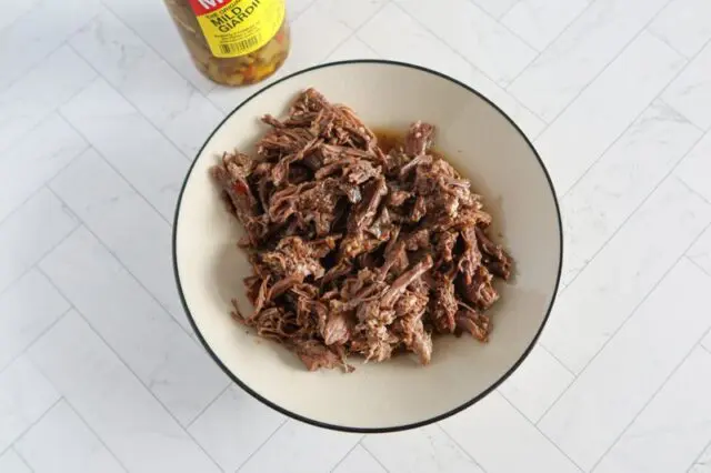 instant pot italian beef for sandwiches, shredded in a bowl