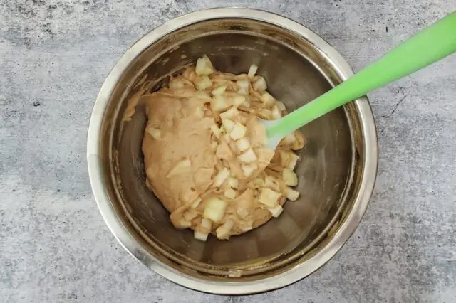 Folding the diced pears into the batter.