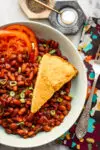 Instant Pot baked pinto beans with cornbread and tomatoes.