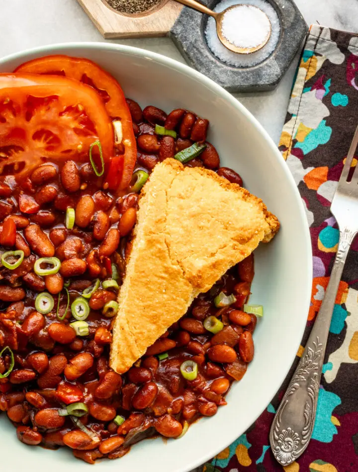 Instant Pot baked pinto beans with cornbread and tomatoes.