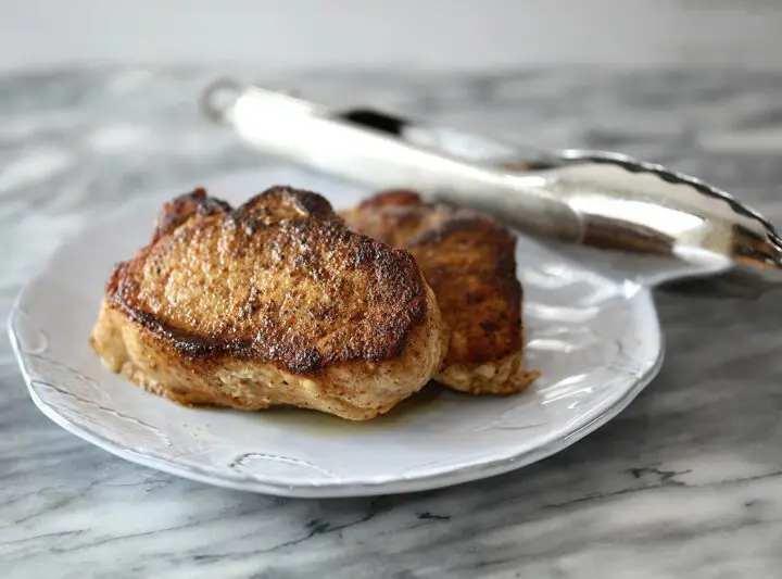 instant pot pork chops on a plate with tongs in the background