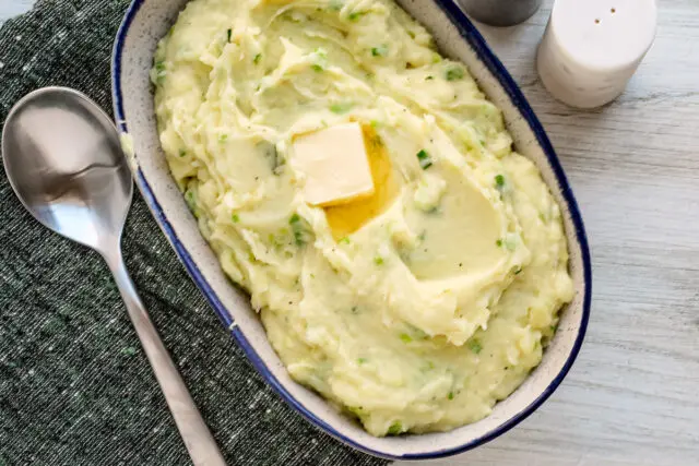 Mashed Irish champ mashed potatoes with scallions and a pat of butter, ready to enjoy.