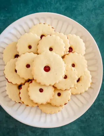 A plate of baked jammie dodgers filled with raspberry jam.