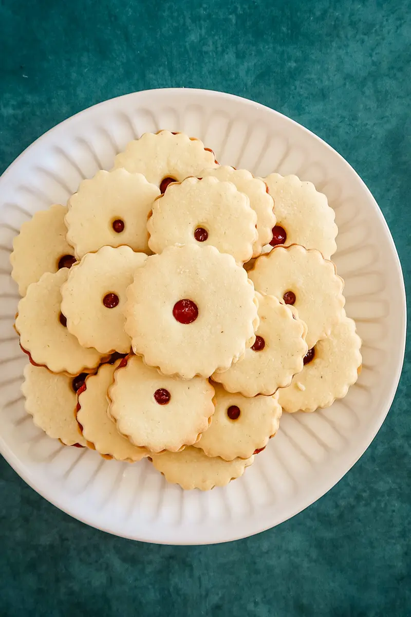 A plate of baked jammie dodgers filled with raspberry jam.