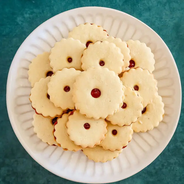 A plate of baked jammie dodgers filled with raspberry jam.