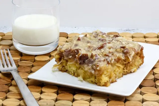 a slice of Cajun cake on a plate with a glass of milk