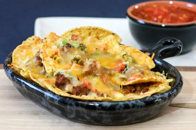 A luncheon plate full of loaded nachos