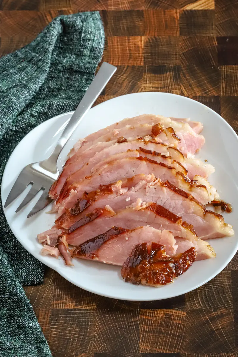 Sliced maple and brown sugar glazed ham on a serving platter.