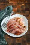 Sliced maple and brown sugar glazed ham on a serving platter.