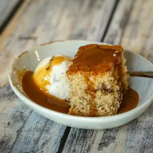 maple walnut cake with ice cream and caramel sauce in a dessert dish