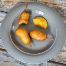 mini corn dogs on a plate with mustard