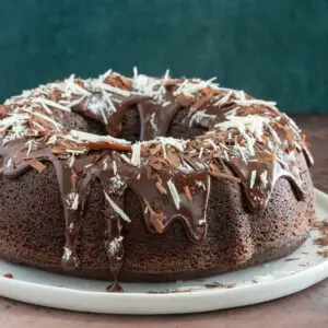 Moist chocolate bundt cake with chocolate glaze and shards of chocolate and white chocolate.