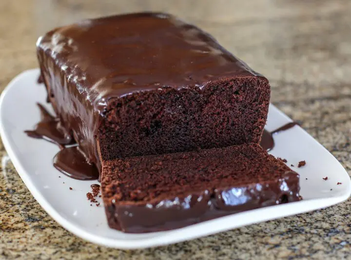 A chocolate loaf cake on a serving tray.